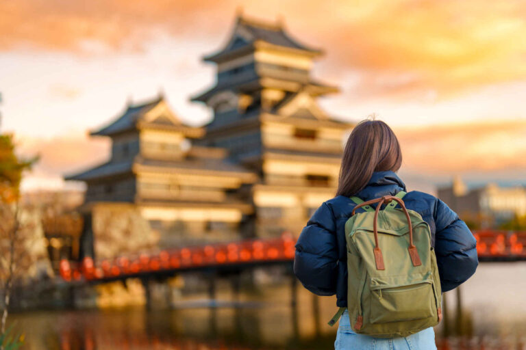 Blog de blog japan Girl with a backpack faces a japanese castle. Travel Japan and learn japanese on a working holiday japan oder studentvisa japan trip.